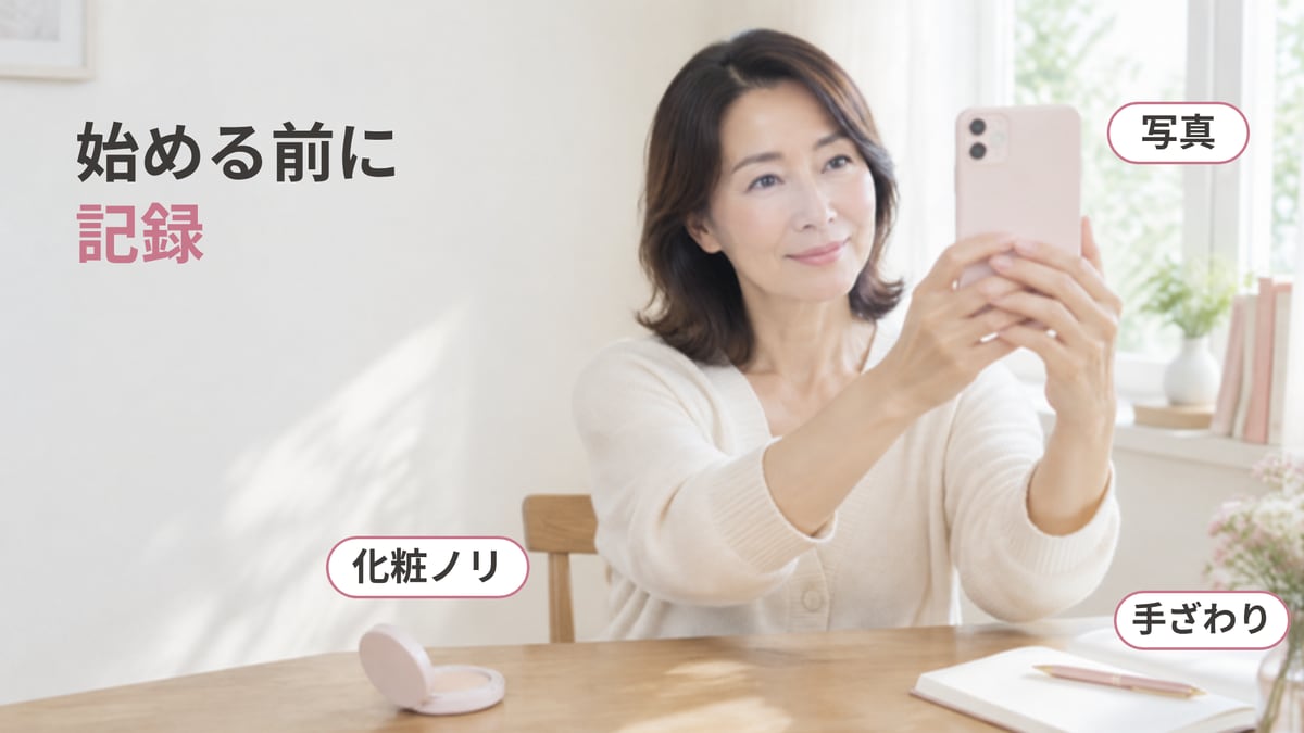 窓辺のテーブルで、スマホで自分の顔を撮り、メモ帳とファンデーションをそばに置いて、始める前の肌を記録している女性の画像